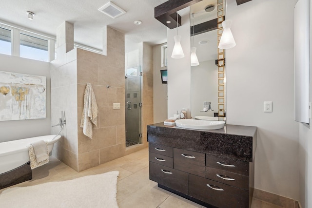 full bathroom with tile patterned flooring, visible vents, vanity, a freestanding bath, and a shower stall