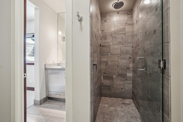 full bathroom featuring a shower stall, baseboards, and vanity