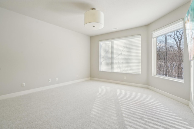 empty room featuring carpet floors and baseboards