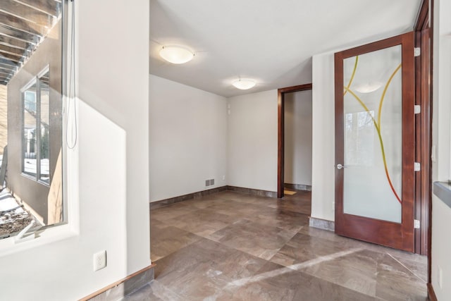 foyer entrance featuring visible vents and baseboards