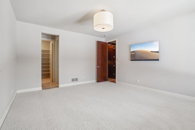 carpeted spare room featuring baseboards and visible vents