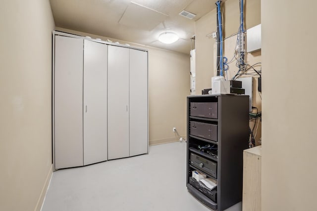 interior space with finished concrete floors, visible vents, and baseboards