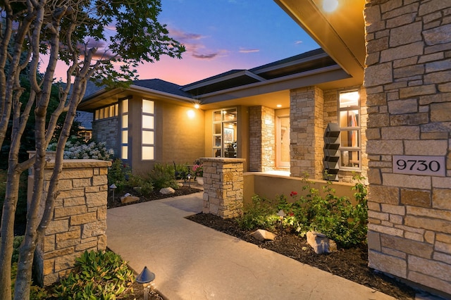9730 Sky Ln, Eden Prairie, MN 55347 - exterior entry at dusk with stone siding