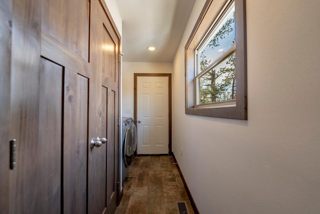 hall featuring visible vents, baseboards, separate washer and dryer, and dark wood-style flooring