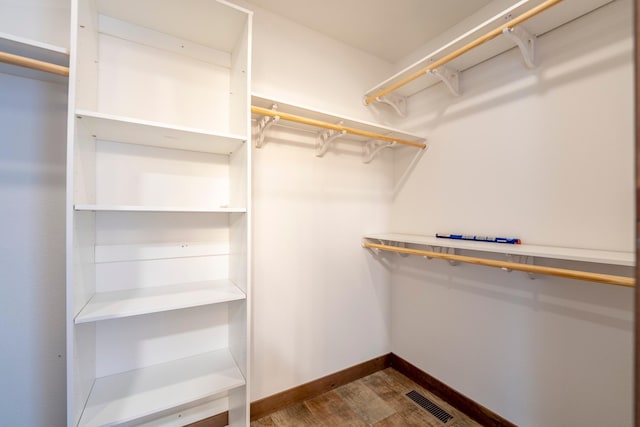 walk in closet featuring visible vents and dark wood-type flooring