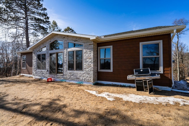 back of property featuring stone siding