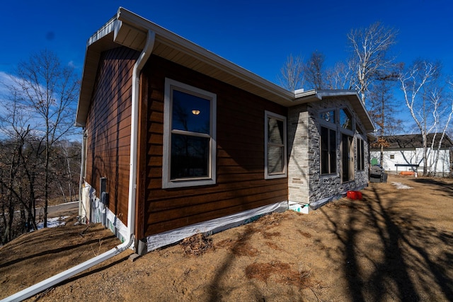 view of side of property with stone siding