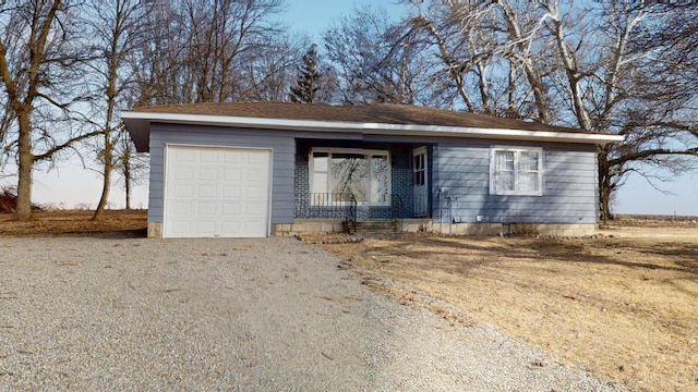 ranch-style home featuring gravel driveway and an attached garage