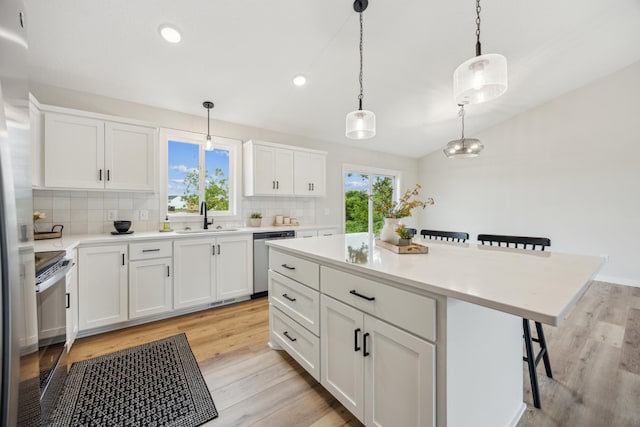 4695 3rd Street Loop NE, Saint Cloud, MN 56304 - kitchen featuring stainless steel appliances, a sink, a breakfast bar, backsplash, and light wood finished floors