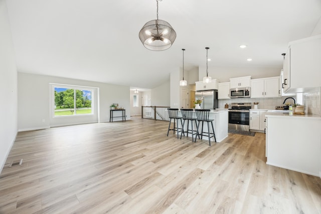 4695 3rd Street Loop NE, Saint Cloud, MN 56304 - kitchen with appliances with stainless steel finishes, vaulted ceiling, a kitchen breakfast bar, a center island, and open floor plan