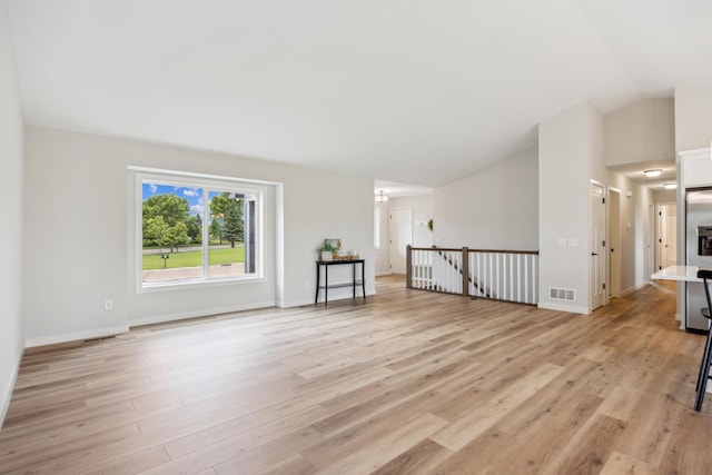 4695 3rd Street Loop NE, Saint Cloud, MN 56304 - unfurnished living room featuring vaulted ceiling, light wood finished floors, and baseboards