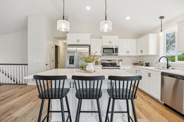 4695 3rd Street Loop NE, Saint Cloud, MN 56304 - kitchen with appliances with stainless steel finishes, a sink, backsplash, vaulted ceiling, and light wood-style flooring