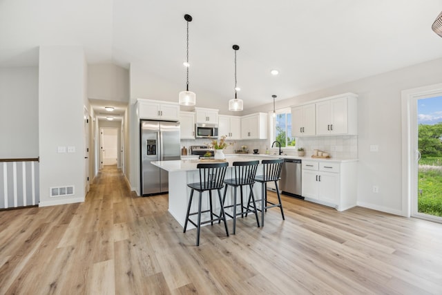 4695 3rd Street Loop NE, Saint Cloud, MN 56304 - kitchen with appliances with stainless steel finishes, a breakfast bar, light wood finished floors, decorative backsplash, and lofted ceiling