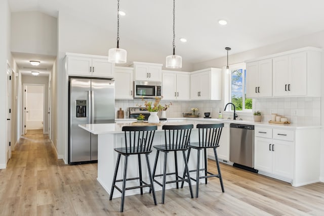4695 3rd Street Loop NE, Saint Cloud, MN 56304 - kitchen featuring stainless steel appliances, a sink, a breakfast bar, vaulted ceiling, and white cabinets