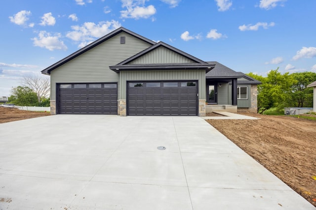4695 3rd Street Loop NE, Saint Cloud, MN 56304 - view of front of property featuring concrete driveway, an attached garage, stone siding, and board and batten siding