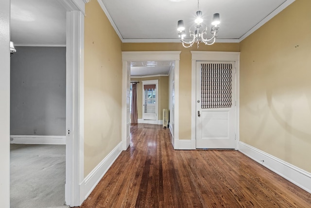 unfurnished dining area with baseboards, radiator heating unit, wood finished floors, an inviting chandelier, and crown molding