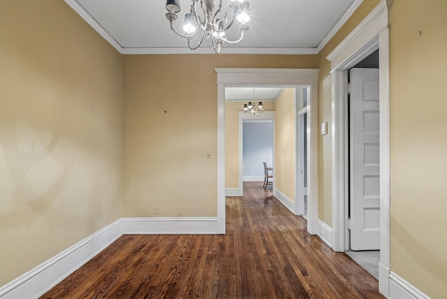 interior space featuring crown molding, baseboards, a notable chandelier, and wood finished floors