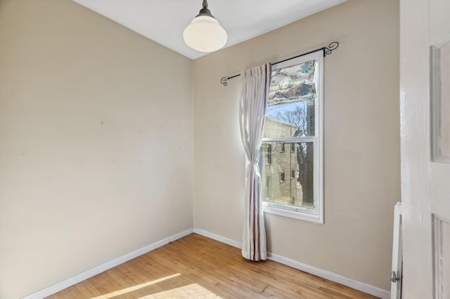 empty room featuring light wood-type flooring and baseboards