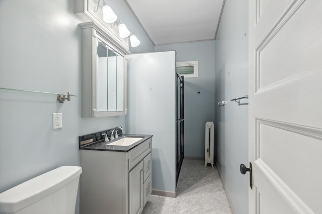 bathroom with toilet, marble finish floor, radiator heating unit, and vanity