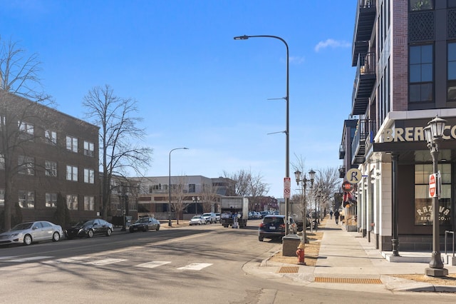 view of road featuring curbs, sidewalks, and street lights