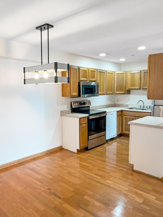 5440 Three Points Blvd Unit 513, Mound, MN 55364 - kitchen featuring stainless steel appliances, a sink, light countertops, brown cabinets, and light wood-style floors