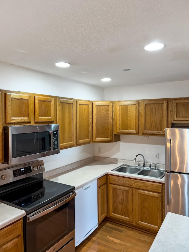 5440 Three Points Blvd Unit 513, Mound, MN 55364 - kitchen with appliances with stainless steel finishes, a sink, light countertops, brown cabinetry, and recessed lighting