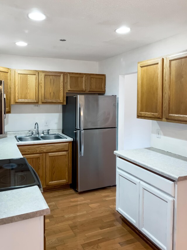 5440 Three Points Blvd Unit 513, Mound, MN 55364 - kitchen with freestanding refrigerator, electric range, a sink, light wood-style floors, and light countertops