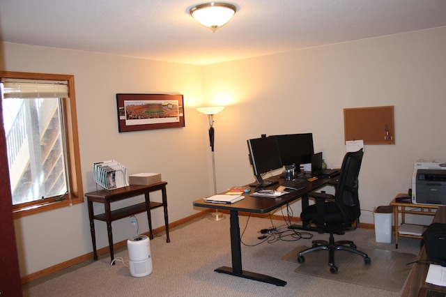 carpeted office space featuring plenty of natural light and baseboards