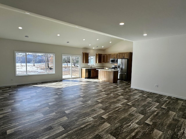 unfurnished living room with dark wood-style flooring, recessed lighting, lofted ceiling, a sink, and baseboards