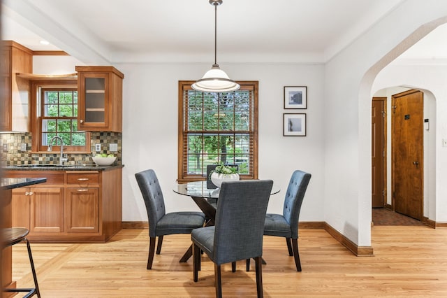 5824 10th Ave S, Minneapolis, MN 55417 - dining area featuring arched walkways, light wood finished floors, baseboards, and crown molding