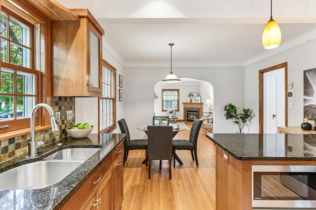 5824 10th Ave S, Minneapolis, MN 55417 - kitchen with a sink, stainless steel microwave, brown cabinets, arched walkways, and light wood finished floors