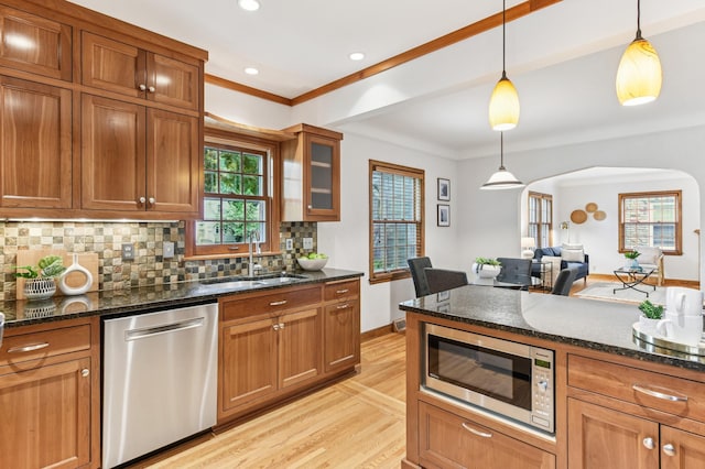 5824 10th Ave S, Minneapolis, MN 55417 - kitchen with stainless steel appliances, a sink, arched walkways, light wood finished floors, and brown cabinets