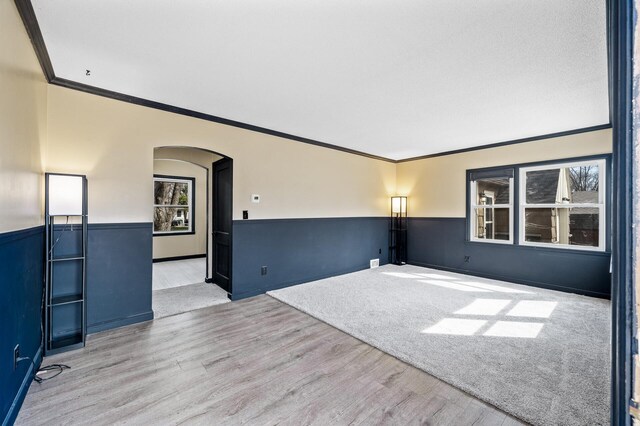 1610 Hennepin Ave N, Glencoe, MN 55336 - spare room with a wainscoted wall, wood finished floors, arched walkways, and crown molding