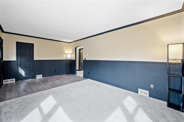 1610 Hennepin Ave N, Glencoe, MN 55336 - unfurnished room with wainscoting, visible vents, arched walkways, and crown molding