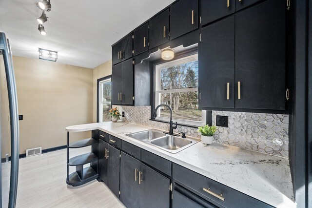 1610 Hennepin Ave N, Glencoe, MN 55336 - kitchen featuring tasteful backsplash, a sink, light countertops, visible vents, and freestanding refrigerator