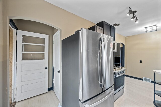 1610 Hennepin Ave N, Glencoe, MN 55336 - kitchen with arched walkways, oven, visible vents, and freestanding refrigerator
