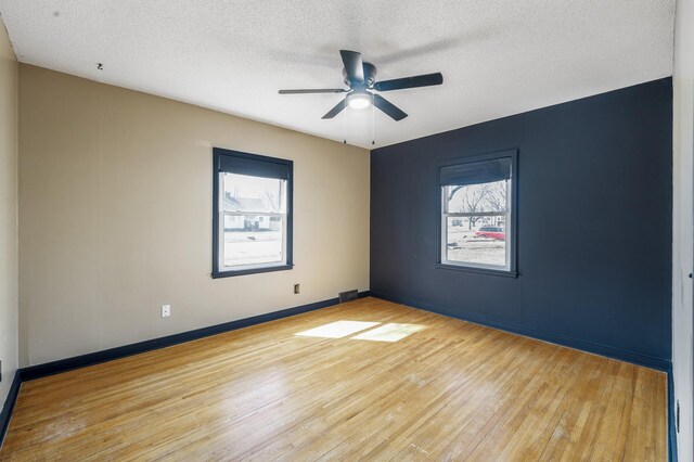 1610 Hennepin Ave N, Glencoe, MN 55336 - spare room featuring a ceiling fan, a textured ceiling, light wood finished floors, and plenty of natural light