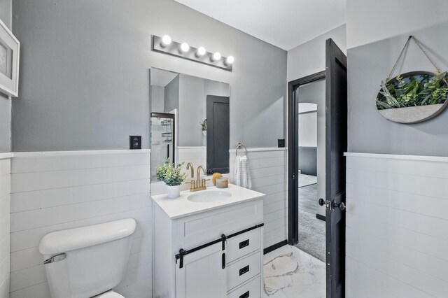 1610 Hennepin Ave N, Glencoe, MN 55336 - bathroom with a wainscoted wall, marble finish floor, vanity, and toilet
