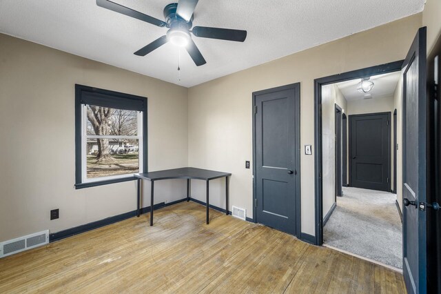 1610 Hennepin Ave N, Glencoe, MN 55336 - unfurnished office with ceiling fan, baseboards, wood finished floors, and visible vents