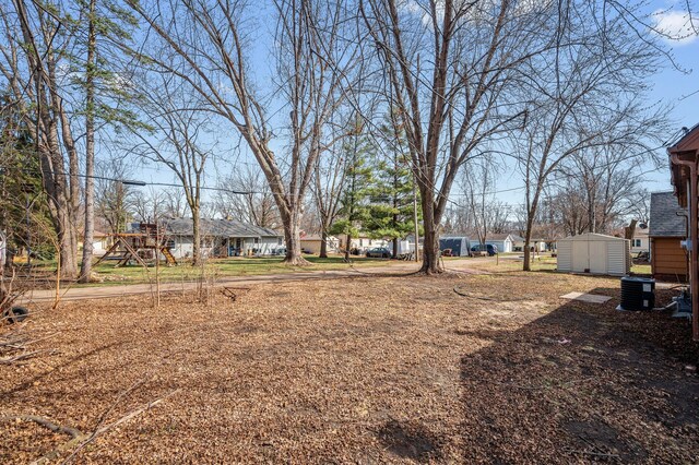 1610 Hennepin Ave N, Glencoe, MN 55336 - view of yard featuring an outdoor structure, a residential view, cooling unit, and a storage shed