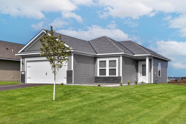 view of front facade featuring driveway, a front lawn, stone siding, roof with shingles, and an attached garage