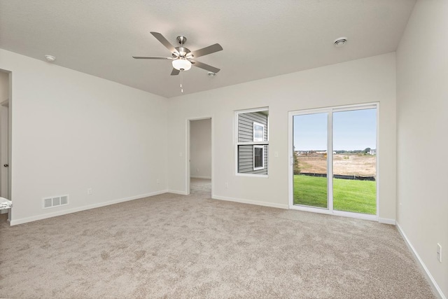 unfurnished room with visible vents, ceiling fan, baseboards, and carpet floors