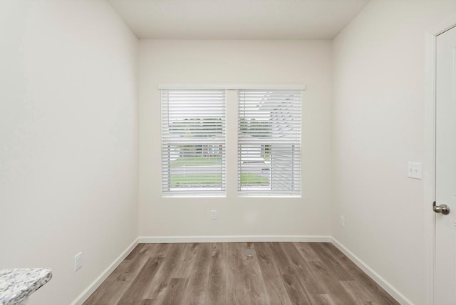 unfurnished room featuring baseboards and wood finished floors