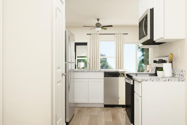 kitchen with ceiling fan, light wood-type flooring, appliances with stainless steel finishes, and white cabinets