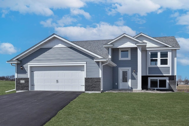 view of front of property featuring roof with shingles, a front yard, a garage, stone siding, and driveway