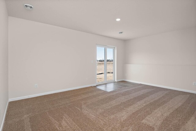 empty room with carpet flooring, recessed lighting, and baseboards