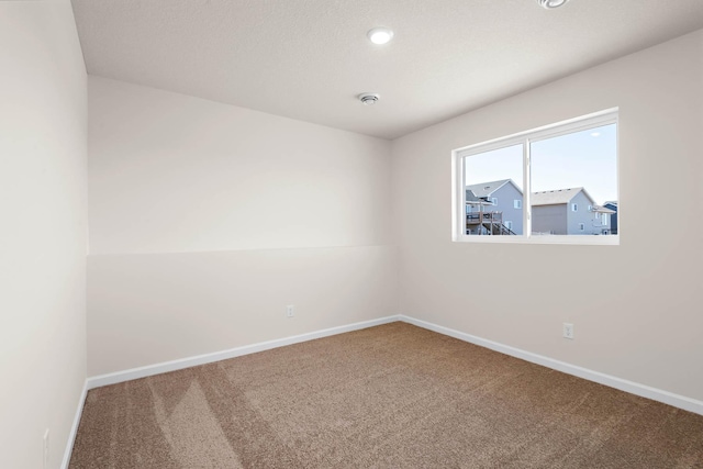 empty room with carpet flooring, recessed lighting, and baseboards