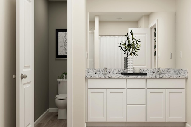 full bathroom featuring vanity, toilet, wood finished floors, and baseboards