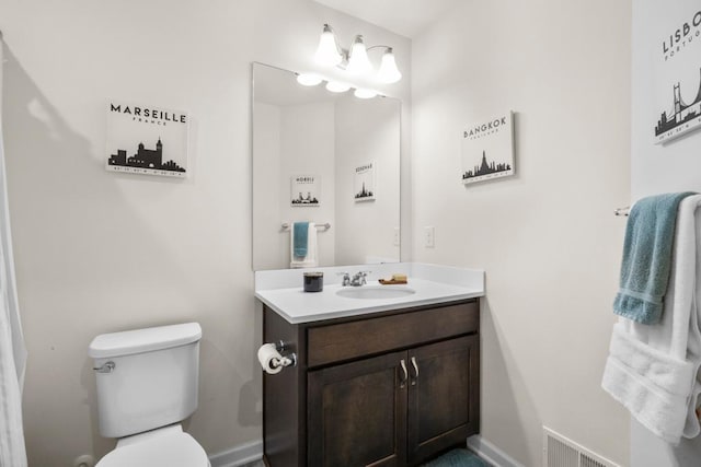 bathroom with baseboards, visible vents, vanity, and toilet