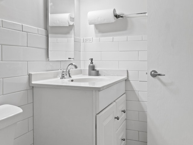 half bathroom featuring tile walls and vanity